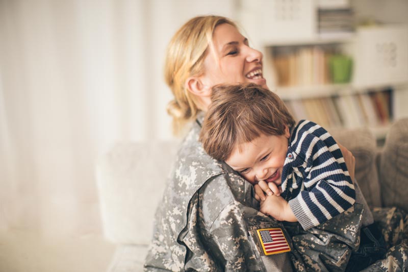 A military mom hugging her son